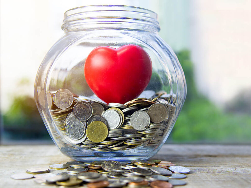 A ceramic heart in a jar of loose change