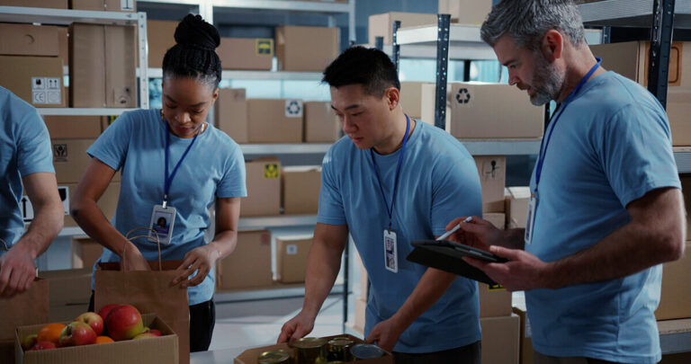 Volunteers in blue shirts boxing up food